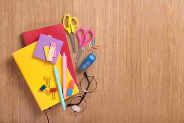 Bright stationery and glasses on a wooden background. Top view, place for text.