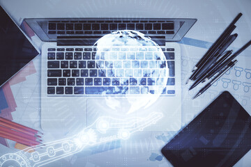 Double exposure of map hologram drawing over study table background with computer. Concept of international network. Top view.