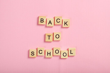 The inscription from cubes back to school on a pink background. Training concept