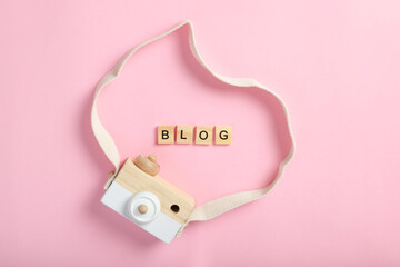 Photo camera and inscription blog on a pink background. View from above