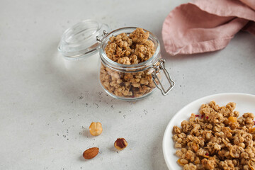 homemade granola with nuts in a plate with a spoon. healthy breakfast concept, vegetarian breakfast. Copy space.