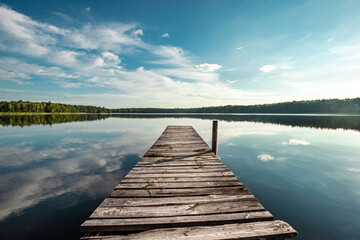 Obraz na płótnie Canvas Wooden pier on the background of a beautiful lake summer dawn landscape. Copy space.