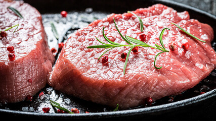Closeup of piece of red meat with herbs for grill
