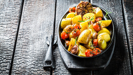 Grilled potato with garlic, rosemary and tomatoes