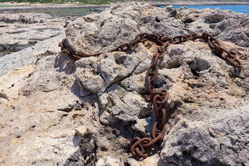 Rusted iron chain on stones.
