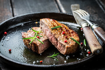 Grilled meat with fresh herbs and pepper on plate