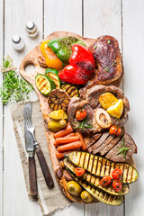 Top view of roasted steak with vegetables on wooden board