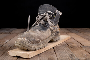 Old work shoe pierced with a nail. An accident at work when renovating a house.