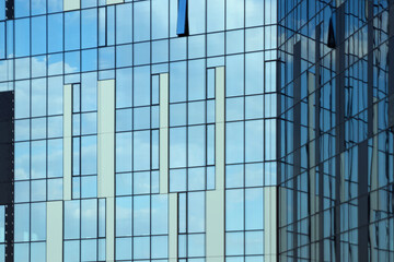Glass office building, view of the sky reflected in the windows. Concept for work, business, offices. Copy space.