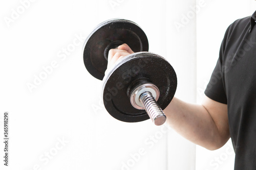 ダンベルを使って自宅の部屋で筋トレする男性 Arm Wall Mural A Nagatani Jungo