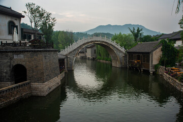 Fototapeta na wymiar Historical small bridge over the river in a village