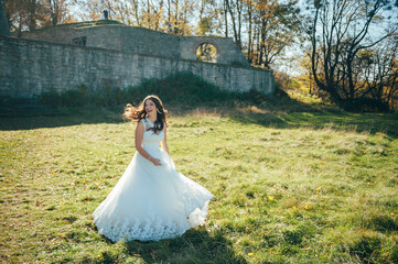 Beautiful happy bride outdoors at sunset. Beautiful woman. Beautiful bride in white dress. Sexy bride. Bride portrait wedding makeup and hairstyle, fashion.