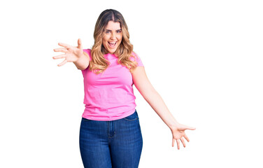 Obraz premium Young caucasian woman wearing sportswear looking at the camera smiling with open arms for hug. cheerful expression embracing happiness.