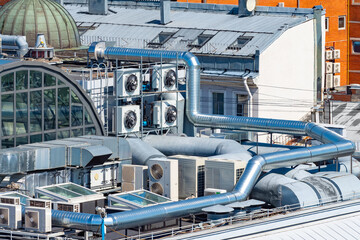 Ventilation system on roof of the building. Air conditioners near ventilation pipes. Engineering...