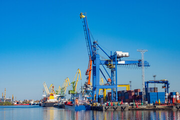 Fototapeta na wymiar Cargo port. Freight port and loading cranes sky background. Sea loading terminal. Cargo ships in seaport. Ships moored for loading. Transportation by ship. Huge cranes for unloading sea containers