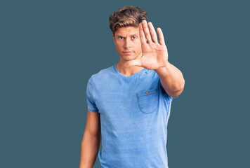 Young handsome man wearing casual clothes doing stop sing with palm of the hand. warning expression...