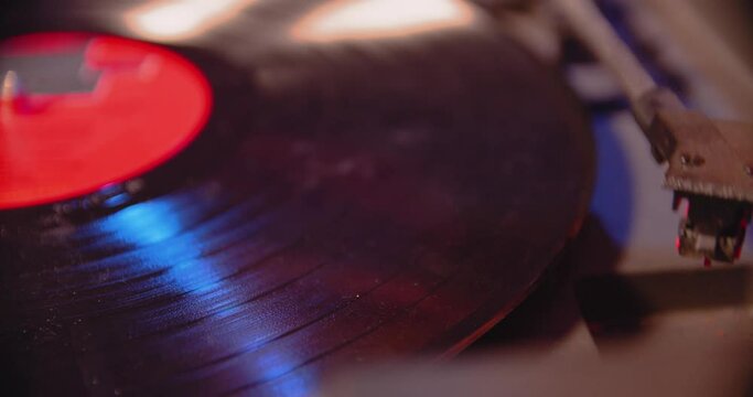 Close Up of record being dropped and needle playing record on old record player.