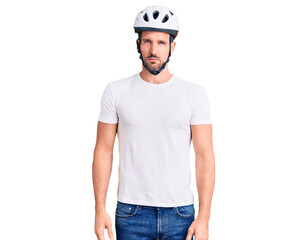 Young handsome man wearing bike helmet skeptic and nervous, frowning upset because of problem. negative person.