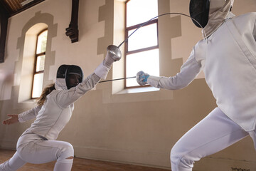 Two female fencers practicing fencing