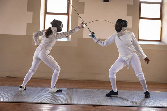 Two female fencers practicing fencing