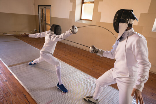 Two male fencers practicing fencing