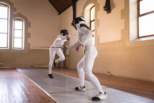 Two female fencers practicing fencing