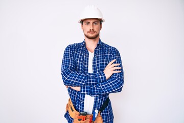 Young handsome man weaing handyman uniform skeptic and nervous, disapproving expression on face with crossed arms. negative person.