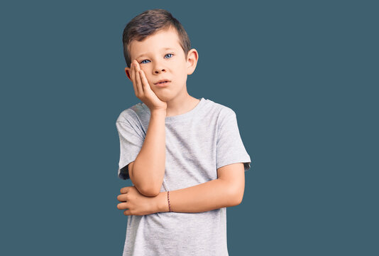 Cute blond kid wearing casual clothes thinking looking tired and bored with depression problems with crossed arms.