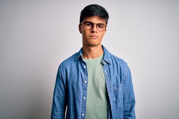 Young handsome man wearing casual shirt and glasses over isolated white background depressed and worry for distress, crying angry and afraid. Sad expression.