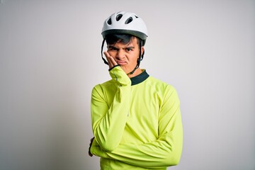 Young handsome cyclist man wearing security bike helmet over isolated white background thinking looking tired and bored with depression problems with crossed arms.