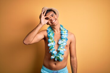 Young handsome tourist man on vacation wearing swimwear and hawaiian lei flowers doing ok gesture...