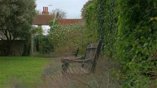 Left-tracking of empty park benches on a windy evening in a classic old English village