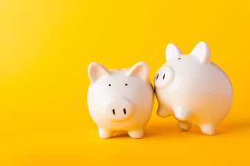 International Friendship Day, Front two small white fat piggy bank, studio shot isolated on yellow background and copy space for use, Finance, deposit saving money concept