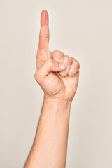 Hand of caucasian young man showing fingers over isolated white background counting number one using index finger, showing idea and understanding