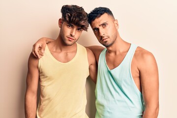 Young gay couple wearing casual clothes relaxed with serious expression on face. simple and natural looking at the camera.