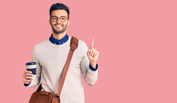 Young handsome hispanic man wearing leather bag and drinking take away coffee surprised with an idea or question pointing finger with happy face, number one