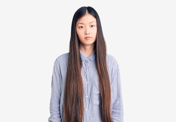 Young beautiful chinese woman wearing casual shirt relaxed with serious expression on face. simple and natural looking at the camera.