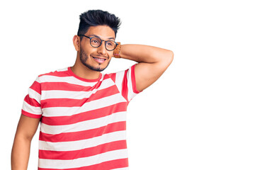 Handsome latin american young man wearing casual clothes and glasses smiling confident touching hair with hand up gesture, posing attractive and fashionable