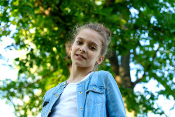 Girl in blue denim clothes posing in the park.