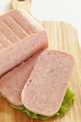 luncheon meat sliced prepared ingredient on wooden board