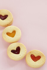 Heart shaped Jam cookie on pink background with copy space