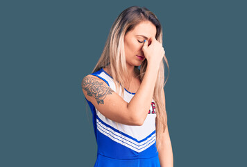 Young beautiful blonde woman wearing cheerleader uniform tired rubbing nose and eyes feeling fatigue and headache. stress and frustration concept.