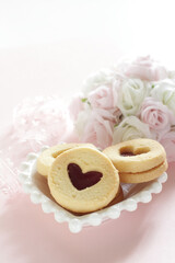 Heart shaped Jam cookie on pink background with copy space