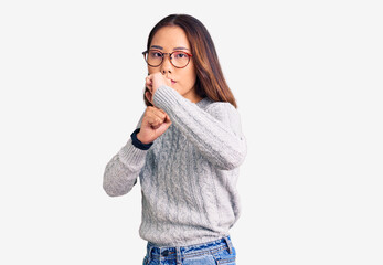 Young beautiful chinese girl wearing casual clothes ready to fight with fist defense gesture, angry and upset face, afraid of problem