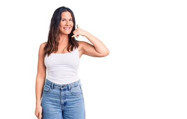 Young beautiful brunette woman wearing casual sleeveless t-shirt smiling doing phone gesture with hand and fingers like talking on the telephone. communicating concepts.