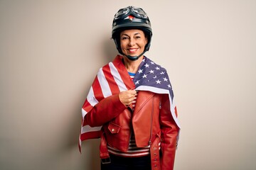 Middle age motorcyclist woman wearing motorcycle helmet and united states flag with a happy face standing and smiling with a confident smile showing teeth