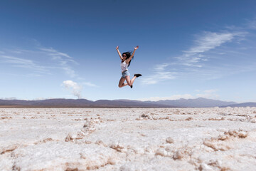 WOMAN JUMPING IN SALT FLATS 