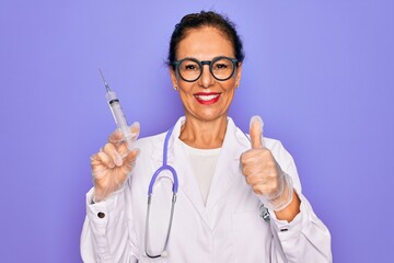 Middle age senior professional doctor woman holding syringe with medical vaccine happy with big...