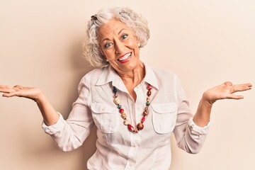 Senior grey-haired woman wearing casual clothes clueless and confused expression with arms and...