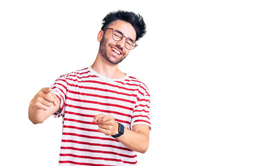 Young hispanic man wearing casual clothes pointing fingers to camera with happy and funny face. good energy and vibes.